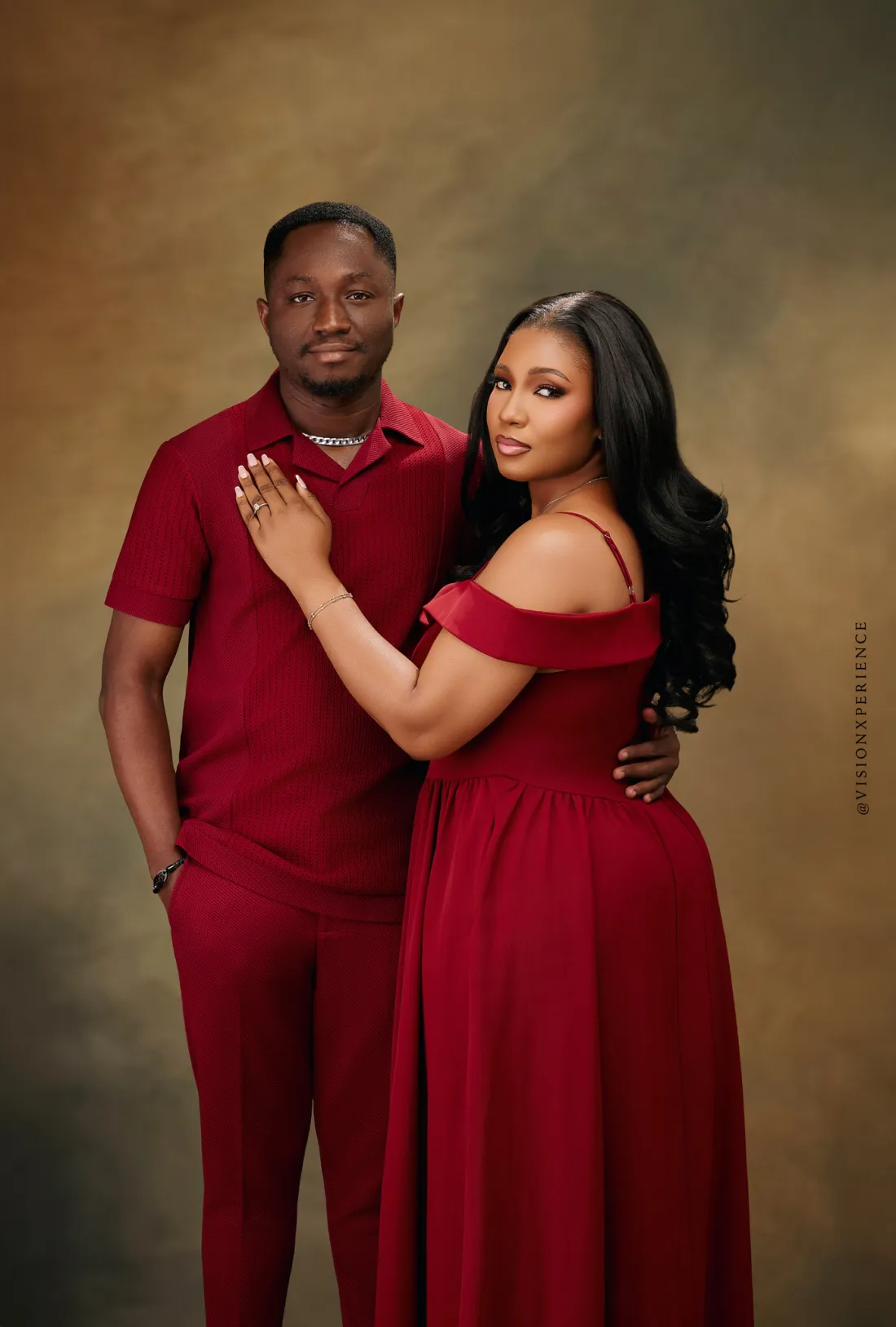 Herbert and Mariam in red, Mariam's hand resting on Herbert's chest