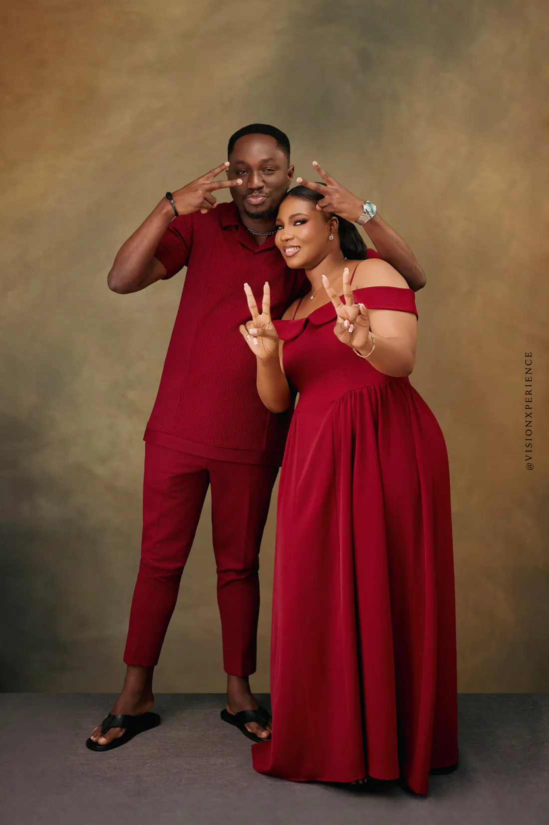 Herbert and Mariam in red, both making peace signs